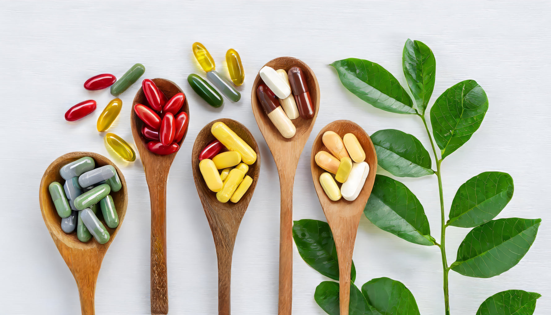 Anti-ageing supplement pills placed beside fresh green leaves symbolizing natural health supplements
